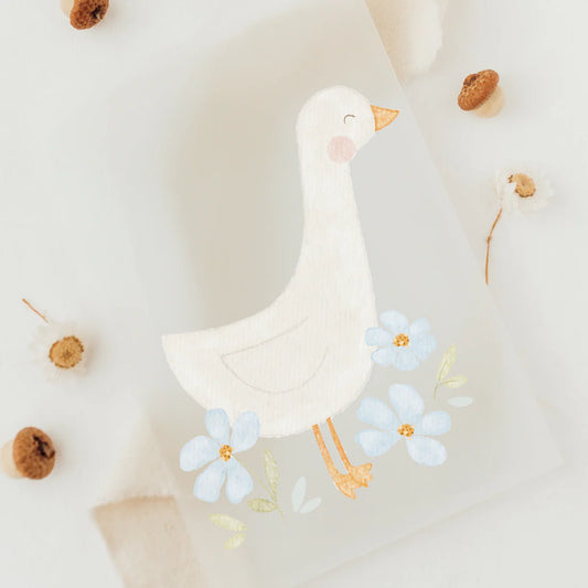 Ein süßes Bügelbild mit einer seitlich gestellten Gans und blauen Blumen um sie herum, zum aufbügeln auf Stoff und Kleidung, Bügelmotiv