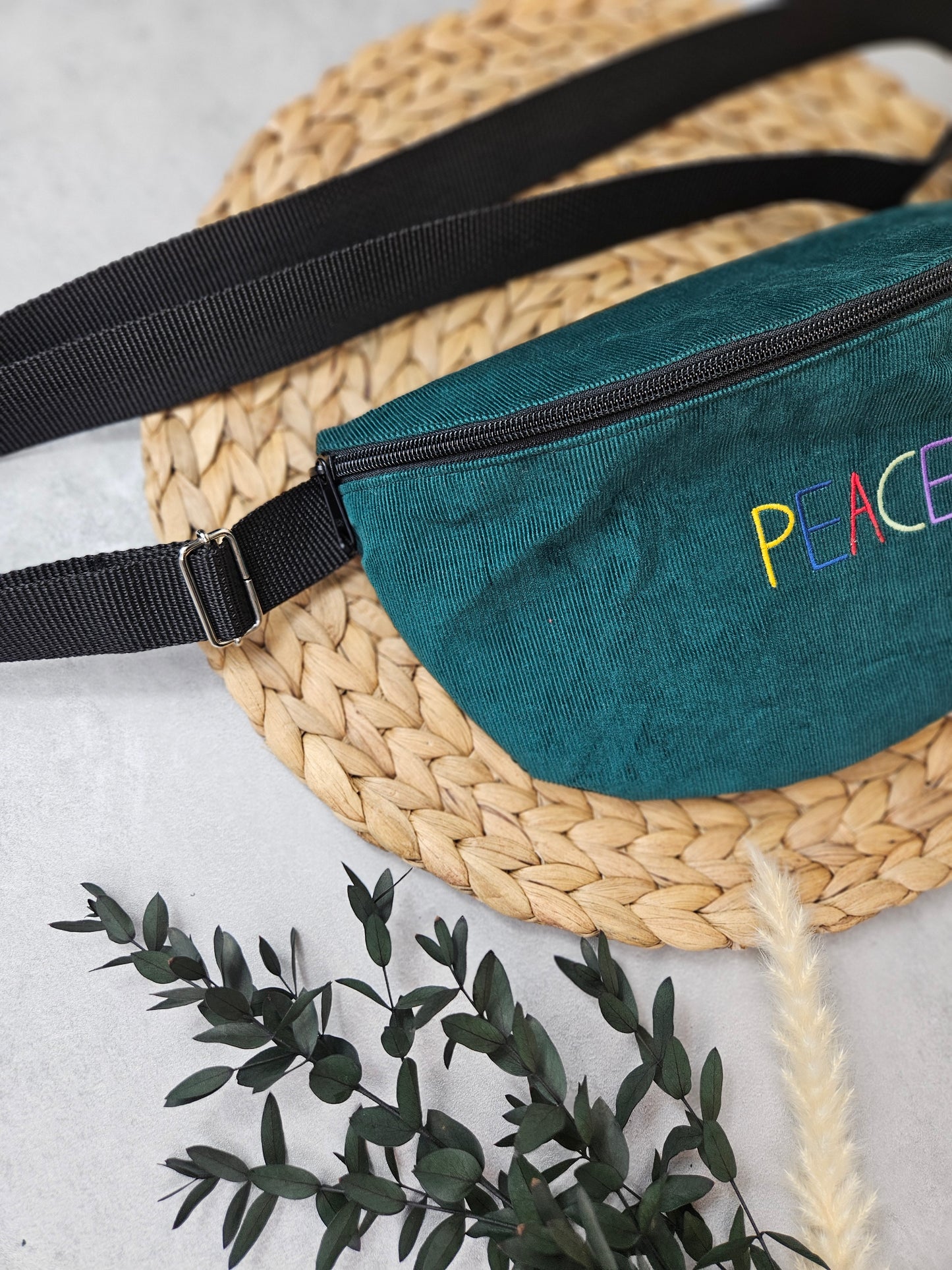 Bauchtasche mit der Aufschrift Peace in Großbuchstaben, einem schwarzen Reißverschluss und schwarzen Gurtband