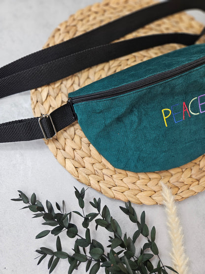 Bauchtasche mit der Aufschrift Peace in Großbuchstaben, einem schwarzen Reißverschluss und schwarzen Gurtband