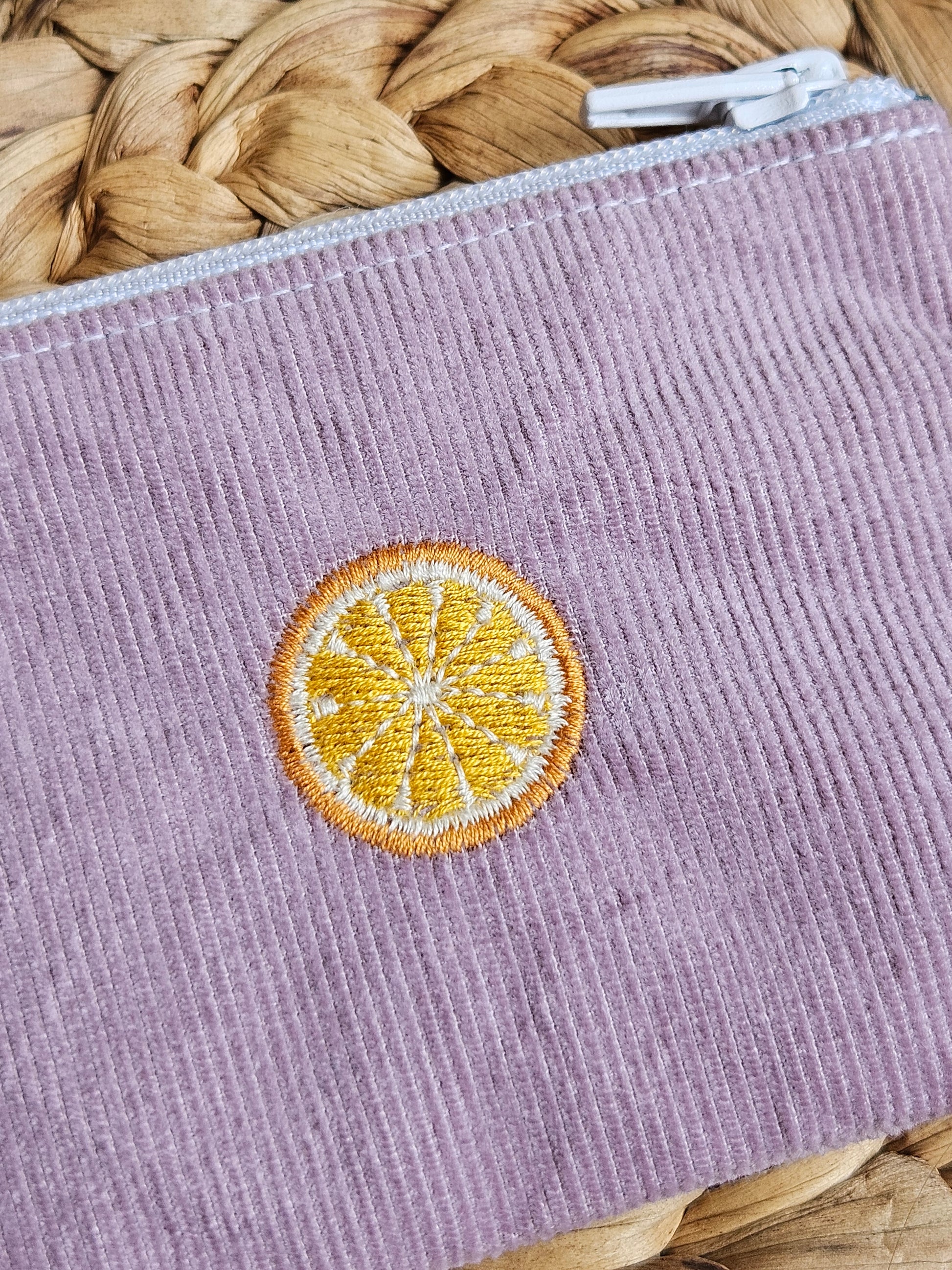 Hier ist eine Detailaufnahme der Orangenstickerei zu sehen.