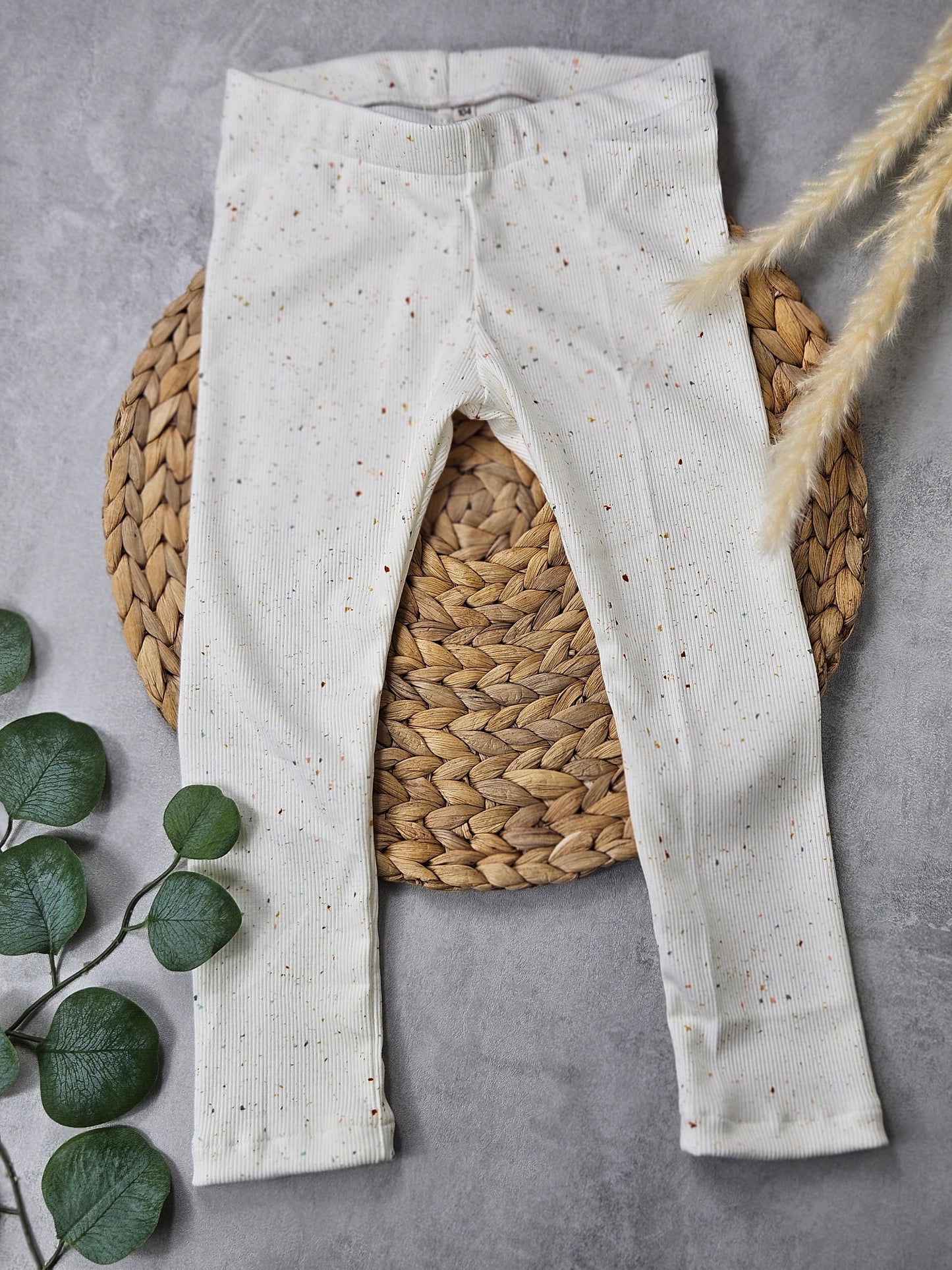 Kinderleggings aus weißem geripptem Stoff und bunten Punkten