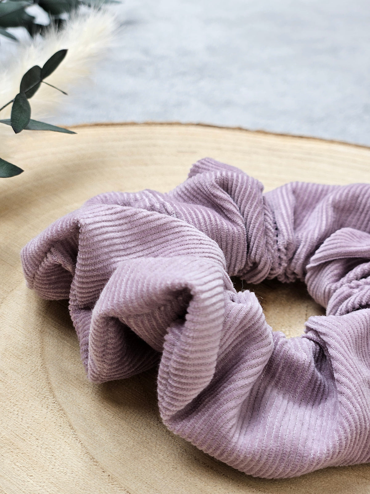 Handgefertigtes Scrunchie in zartem Flieder aus 100 % Bio-Baumwolle mit gerippter Cordstruktur, für einen natürlichen und eleganten Look.
